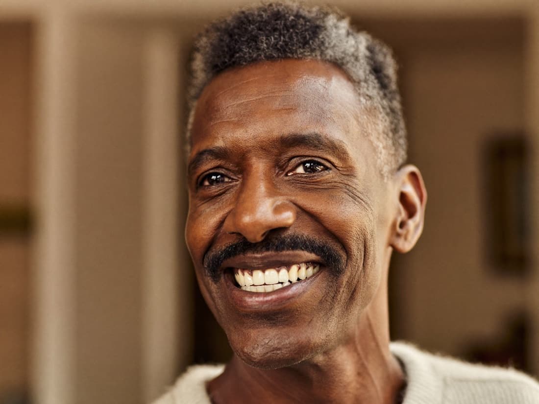 A distinguished man in his fifties smiling warmly